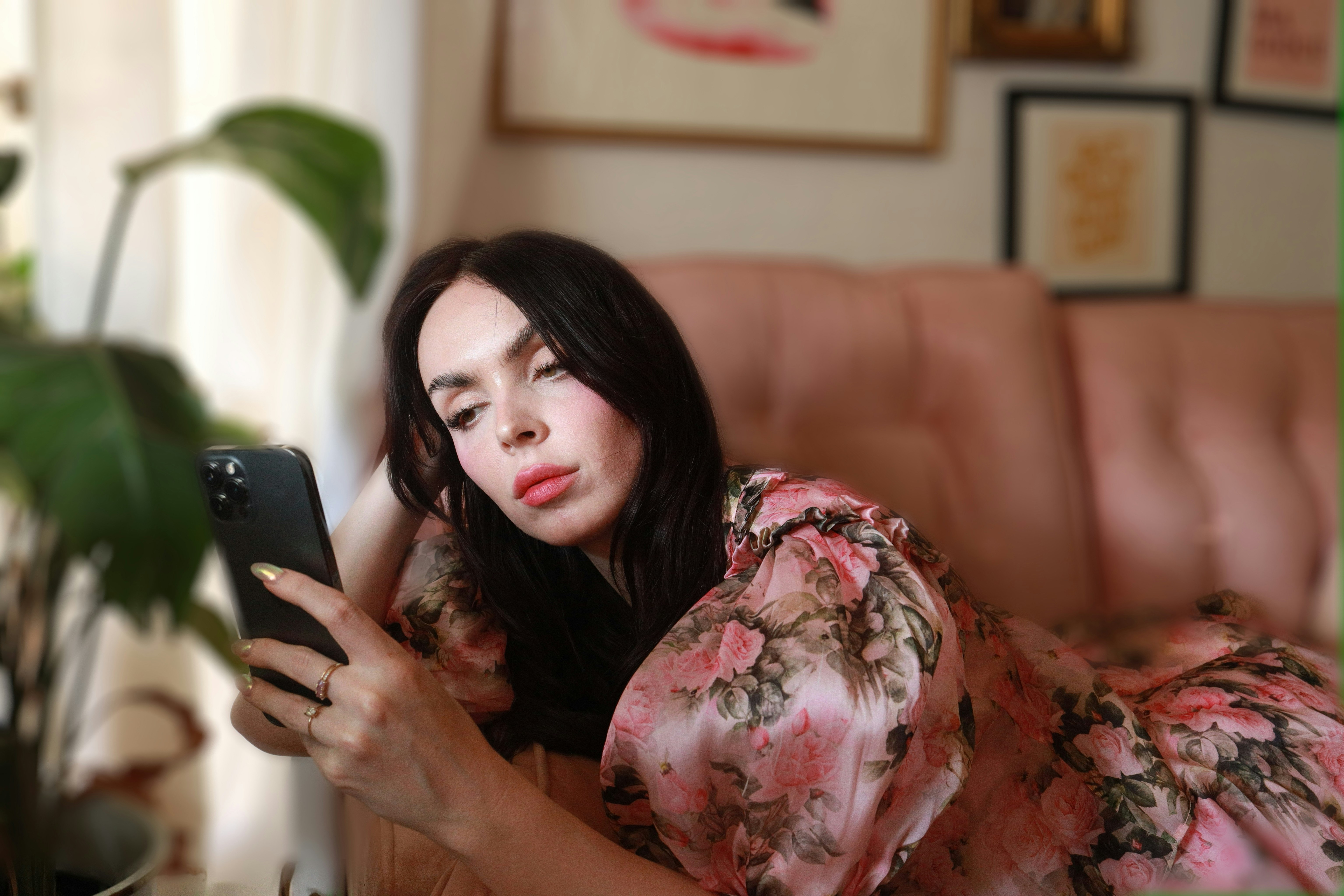 Woman looking at a smartphone while relaxing at home, illustrating how AI and digital tools can support neurodivergent people with everyday tasks.
