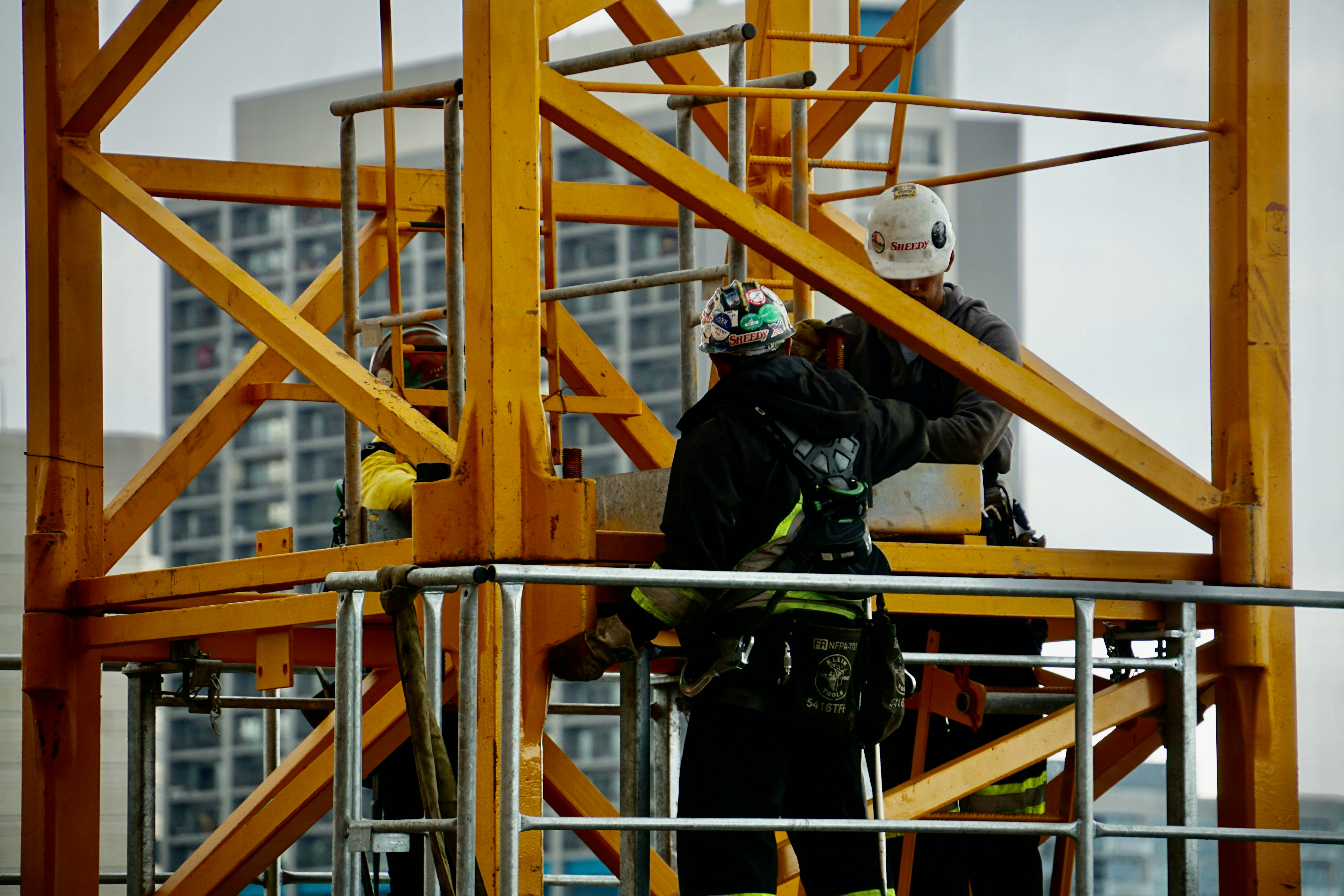 construction worked on a yellow crane on building site